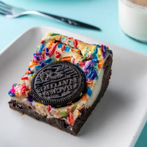 a vegan oreo cheesecake brownie with rainbow sprinkles