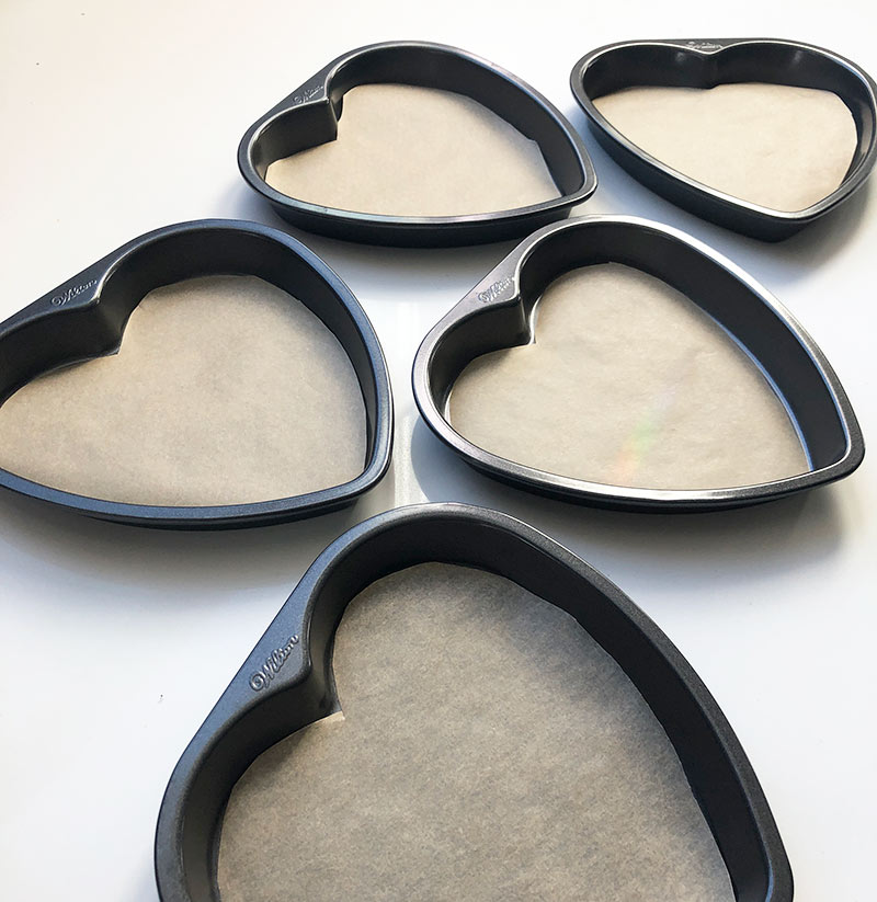 5 heart shaped cake pans, lined with parchment paper
