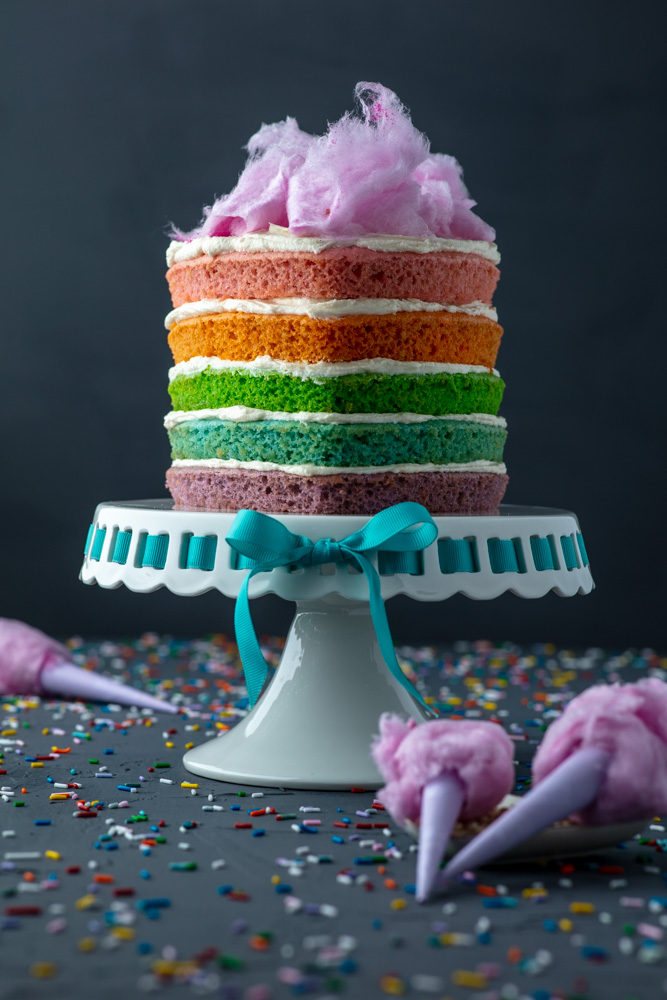 vegan rainbow smash cake topped with vegan pink cotton candy