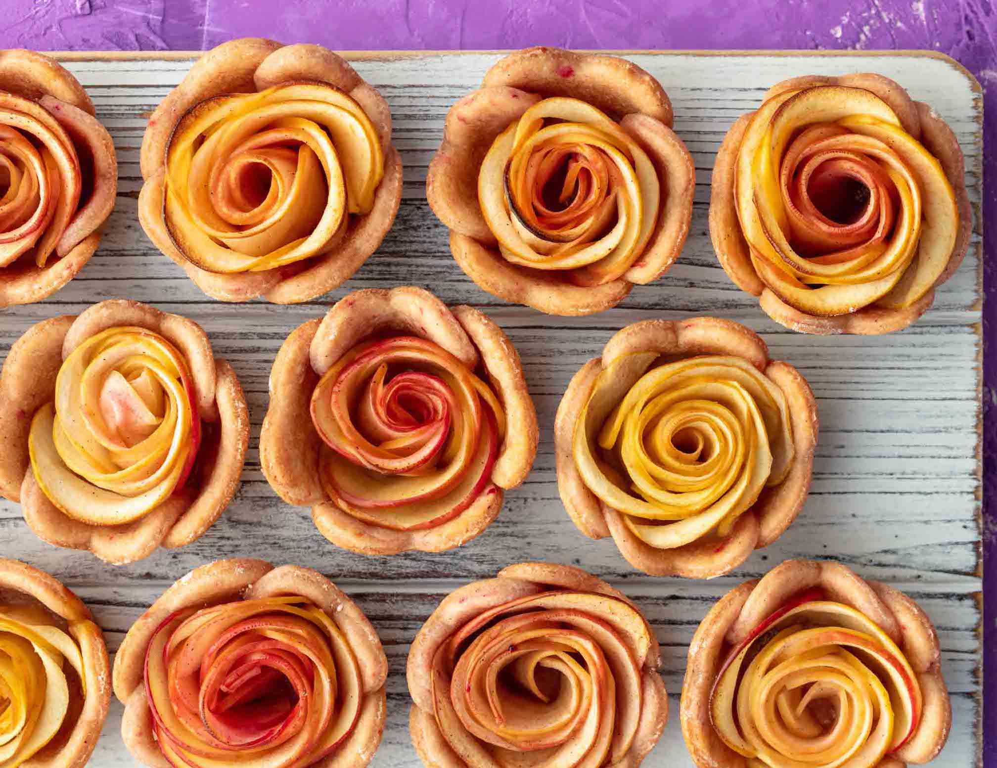 board filled with mini apple tarts that look like roses.