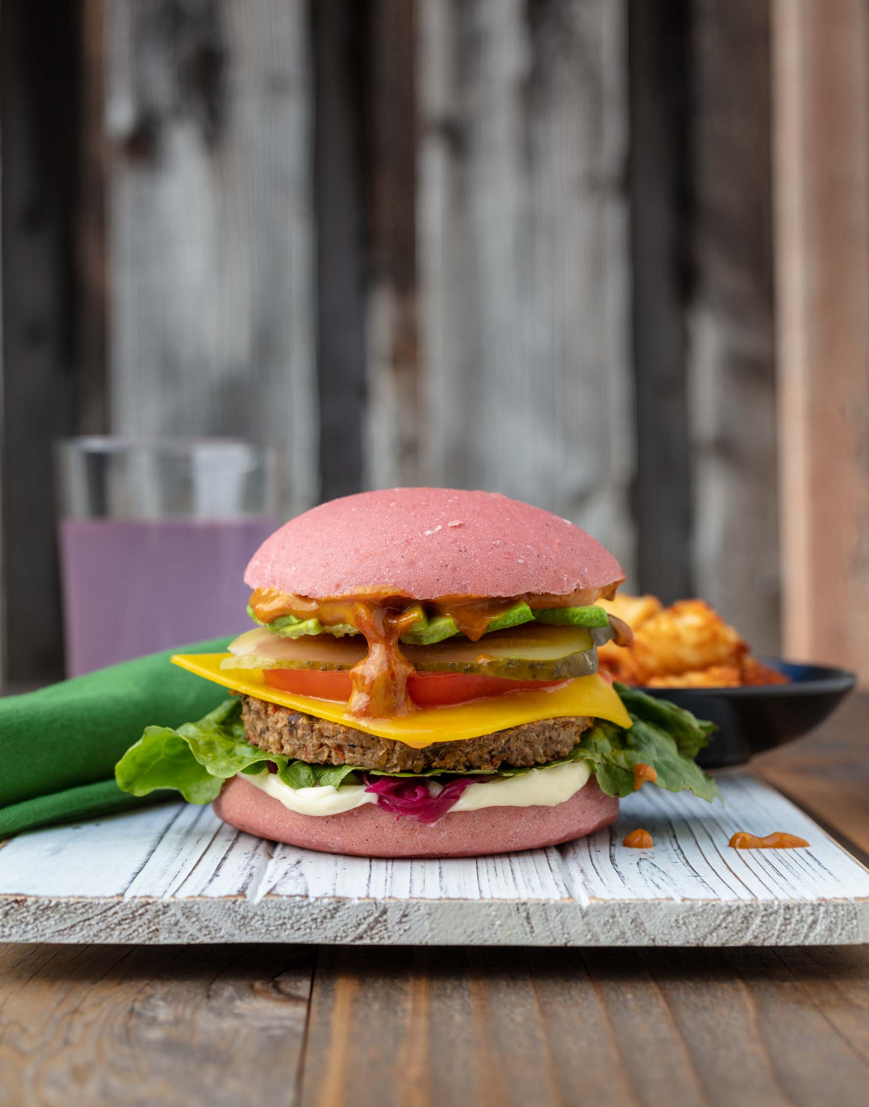 a loaded vegan burger on a pink bun