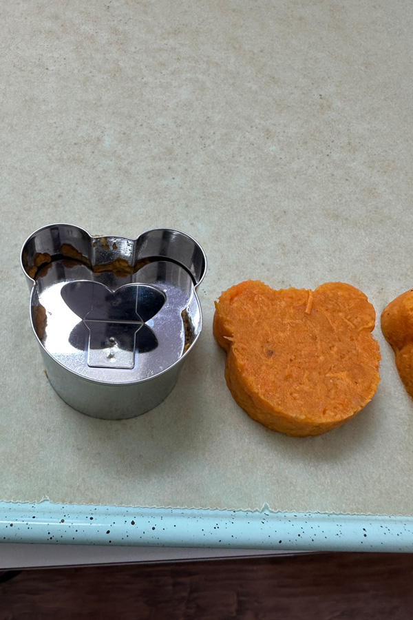 pressing the vegan sweet potatoes into a teddy bear mold