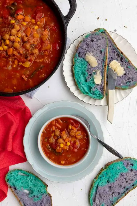 a bowl of 10 vegetable soup with a side of unicorn colored bread
