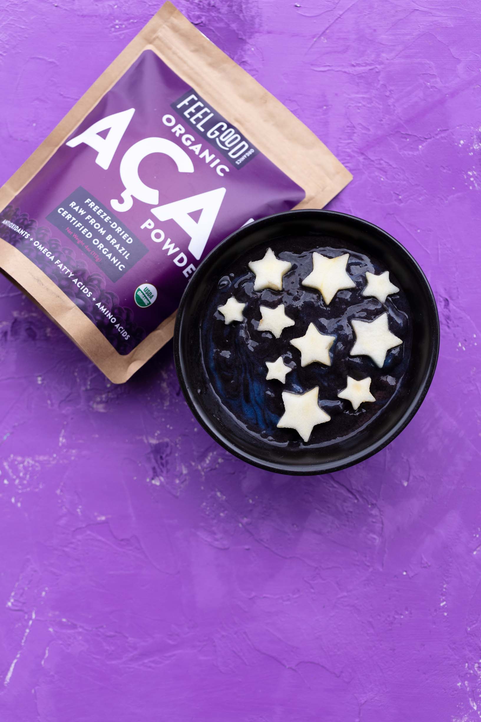 Feel Good Organics acai berry powder next to a galaxy acai smoothie bowl