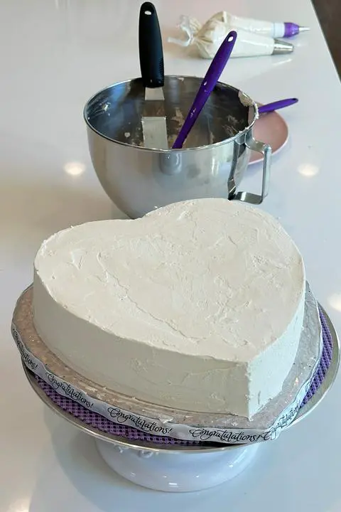 vegan anniversary heart cake covered in white frosting.