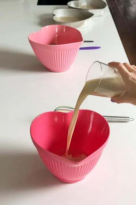 Pouring the nondairy milk into the wet ingredients for the cake batter.