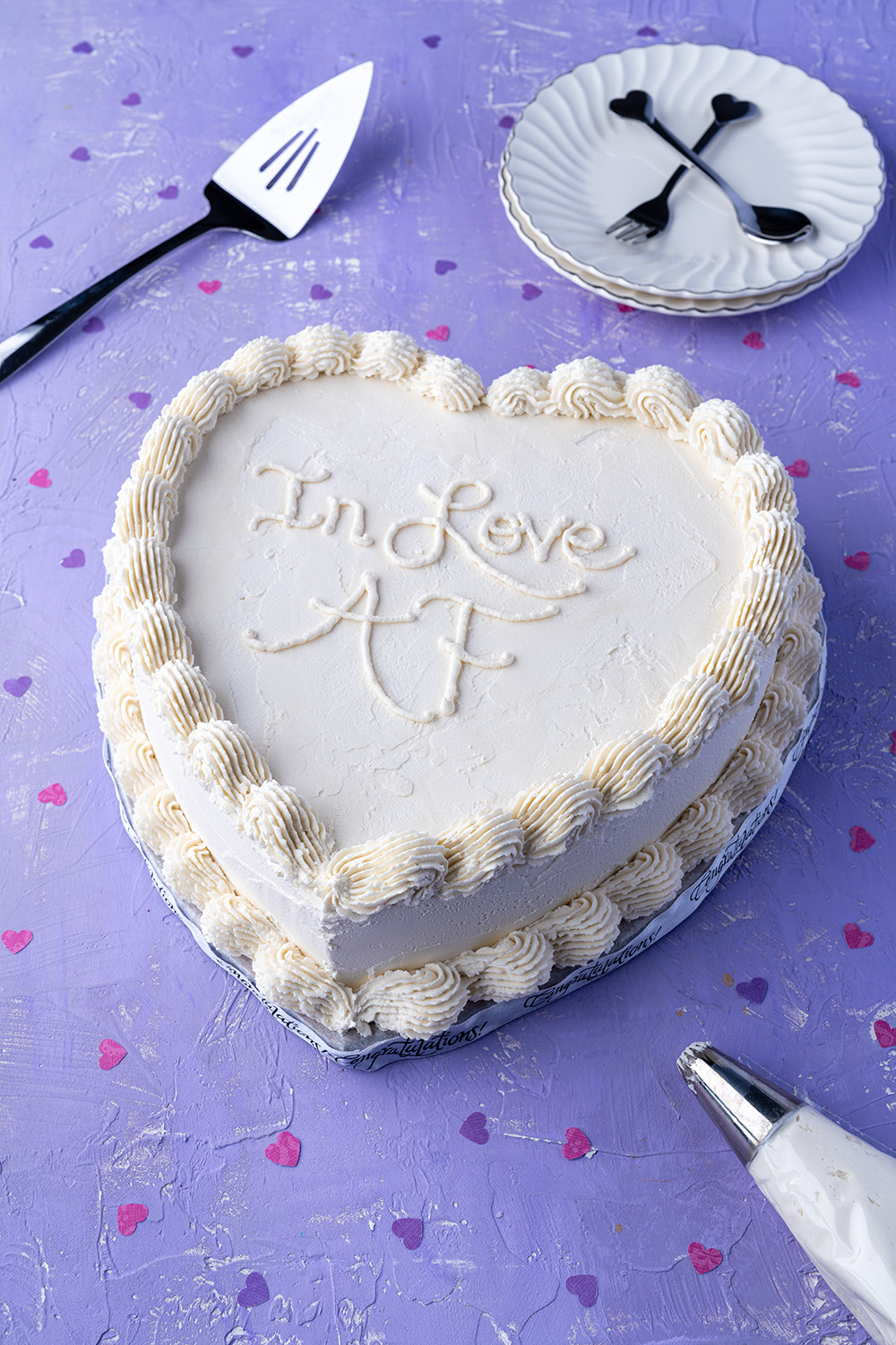 white heart cake that says In Love AF on top.