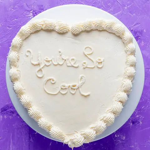 white heart cake that says You’re So Cool.