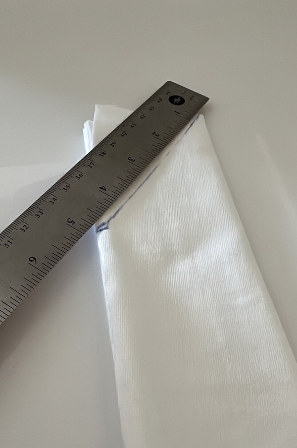 the narrow strip of fabric with a diagonal line drawn with a pen