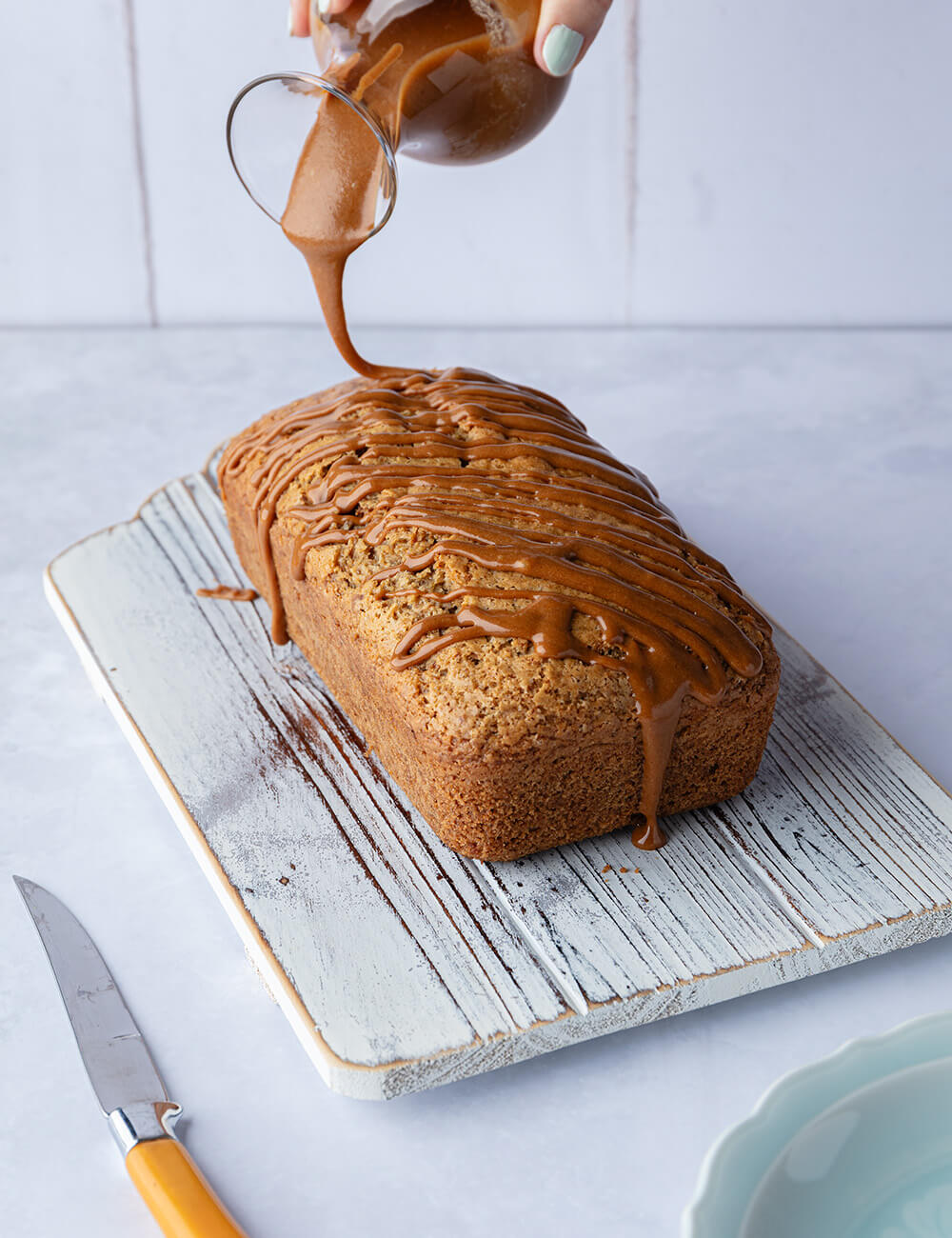 Drizzling biscoff sauce onto the biscoff loaf cake.