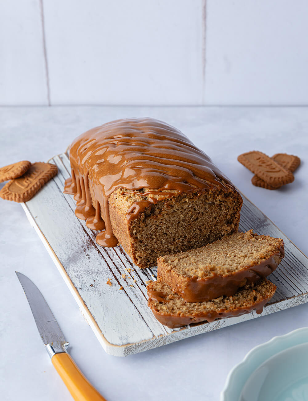 Sliced biscoff loaf cake with biscoff sauce on top.