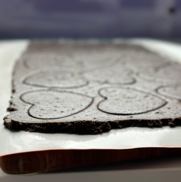 black cocoa cookies on a cutting board ready to go into the freezer