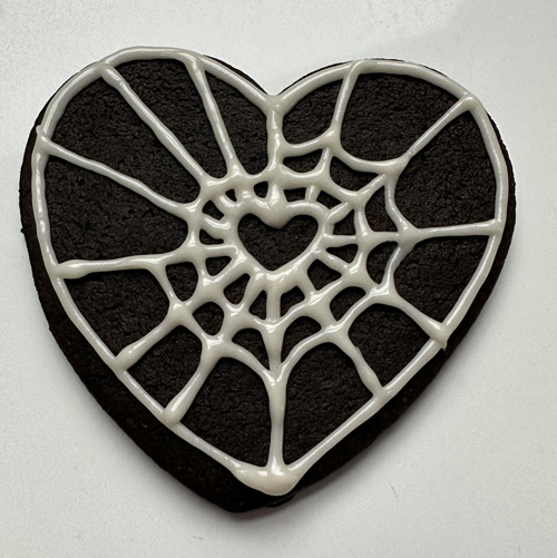 decorating goth core cookies with spider web icing
