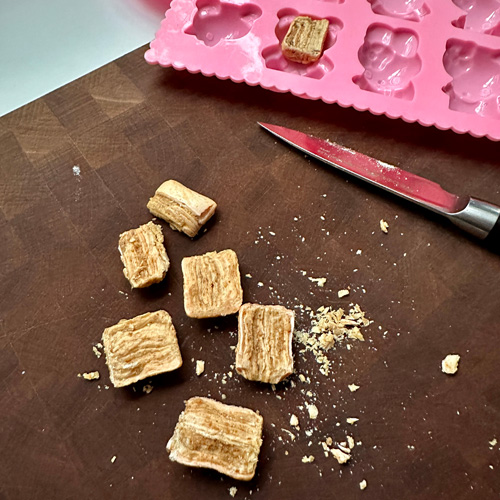 cutting chick-o-sticks to make vegan butterfinger candies