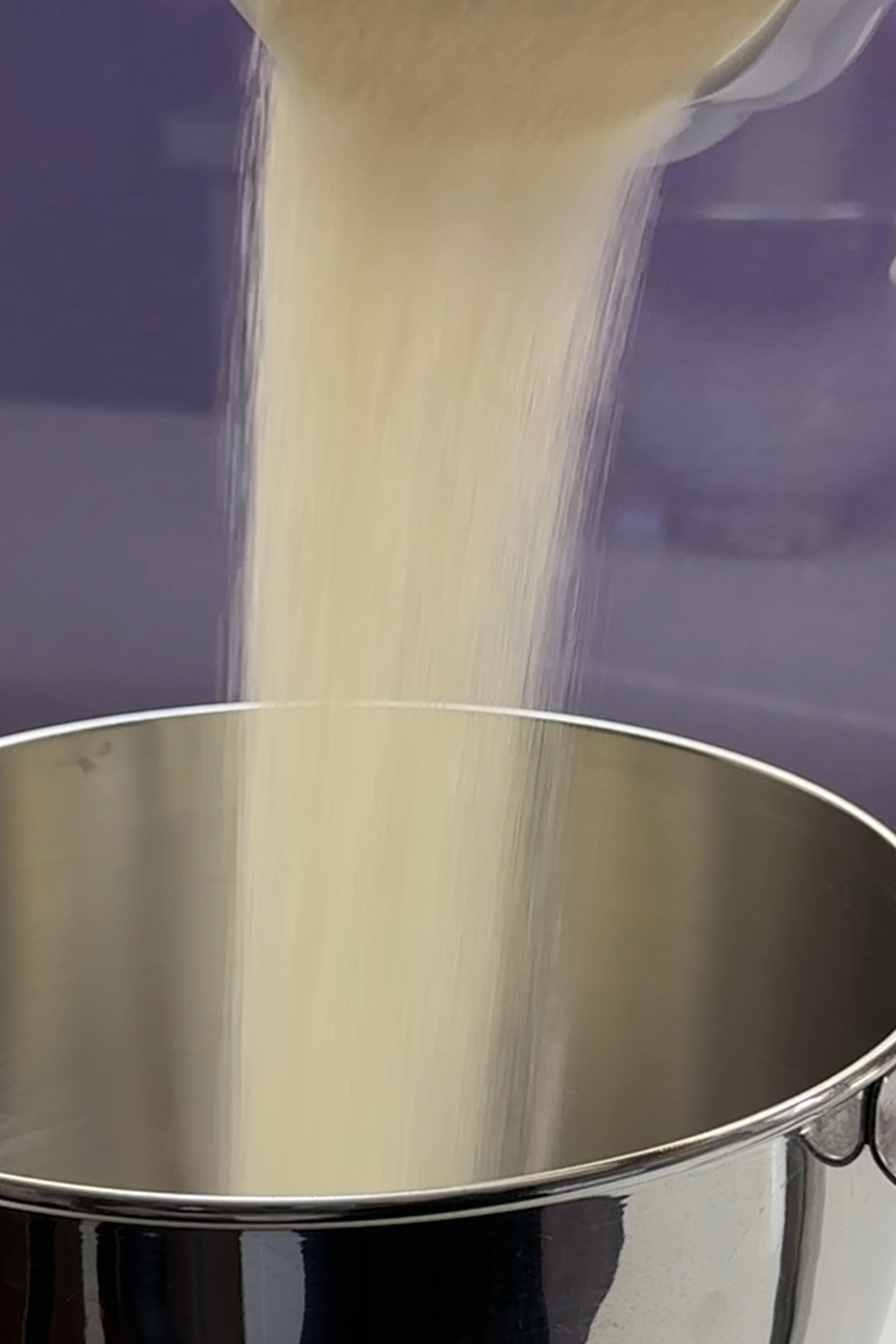 adding vegan sugar to a mixing bowl