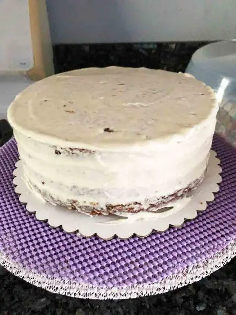 vegan carrot cake with a crumb coat of cream cheese icing