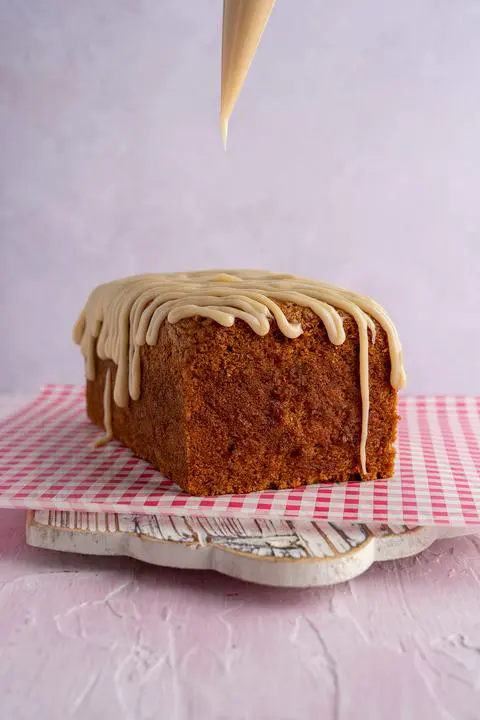 vegan carrot cake loaf with cream cheese icing on top.