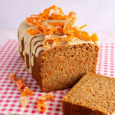 vegan carrot cake loaf with a slice removed to show the inside