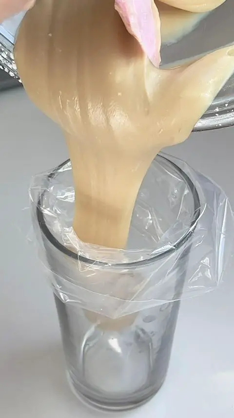 filling a disposable piping bag with vegan cream cheese icing.