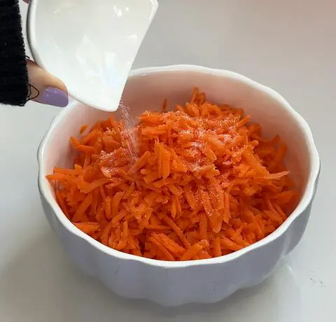 adding salt to the carrots to help the moisture come out of them.