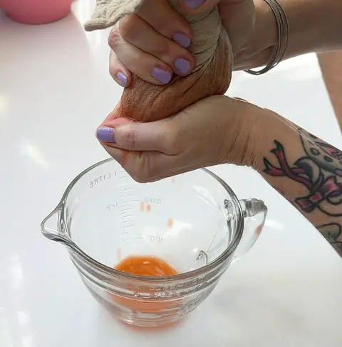 squeezing the liquid out of the carrots.