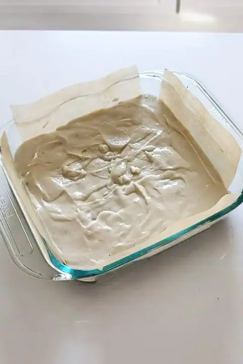 the vegan cheesecake batter covering the vegan brownie batter.