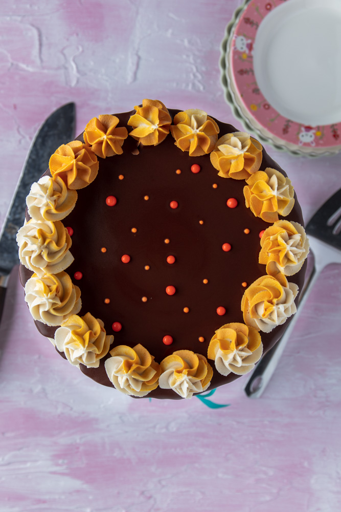 top view of vegan chocolate orange cake with chocolate ganache and orange sprinkles