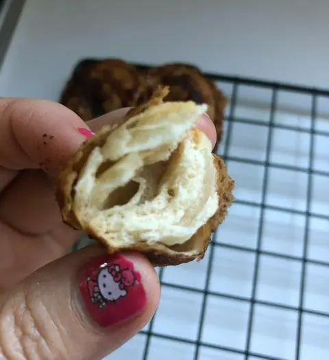 light and flaky texture of the inside of the cinnamon roll donuts