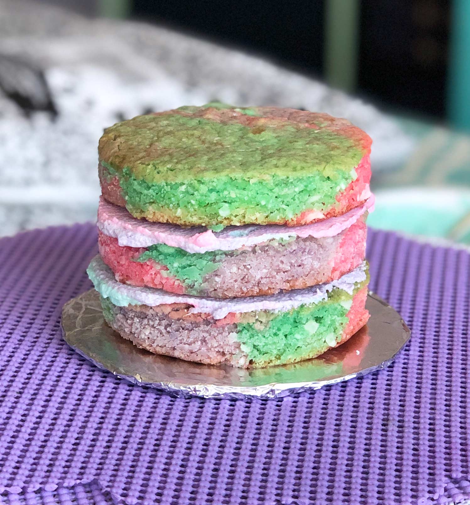 assembling a unicorn-colored mini vegan coconut cake