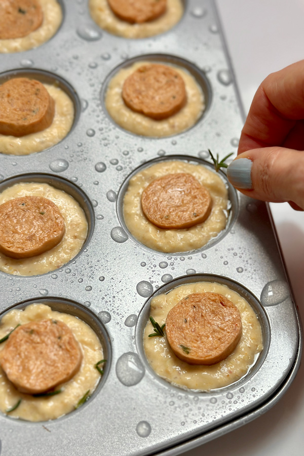 adding rosemark to the mini vegan corn dog muffins before baking them