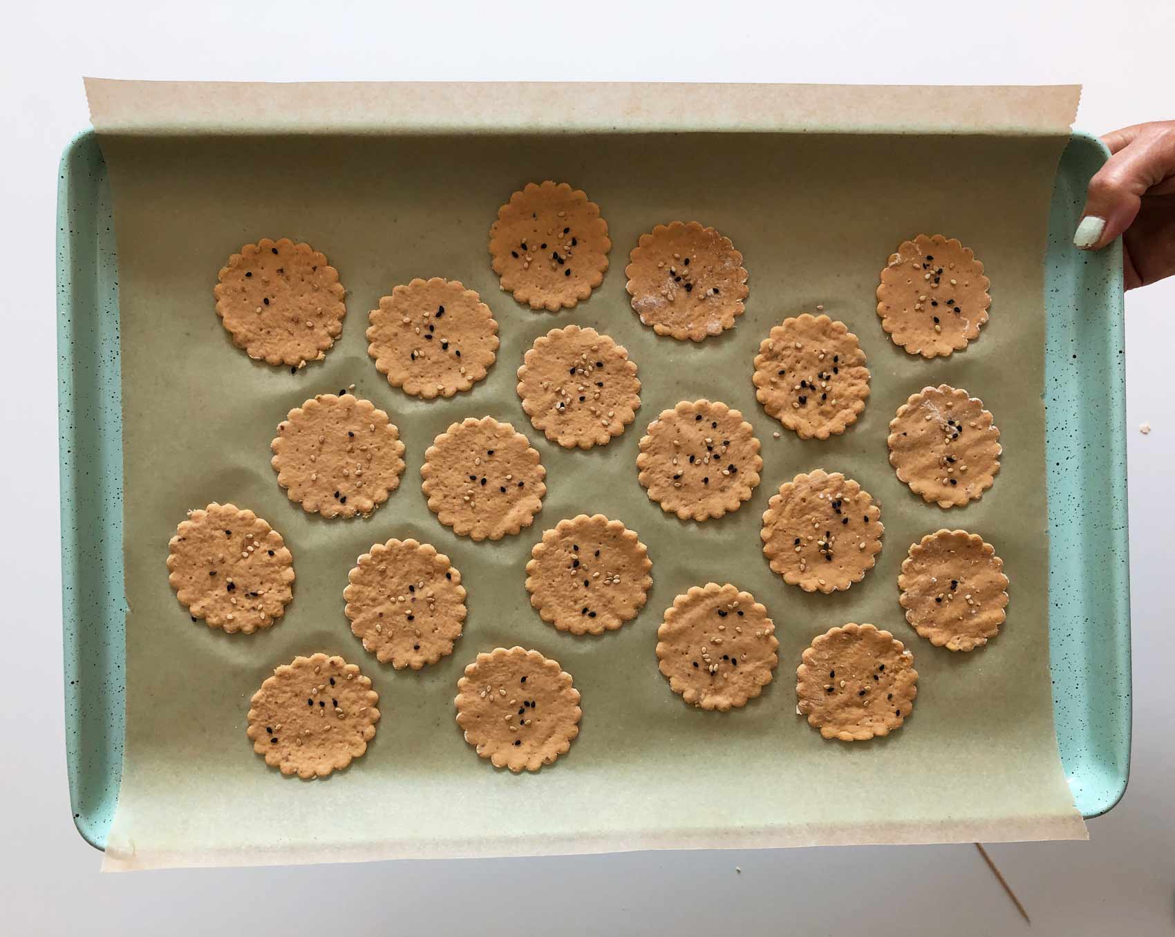 a tray of crackers with seeds, ready to bake