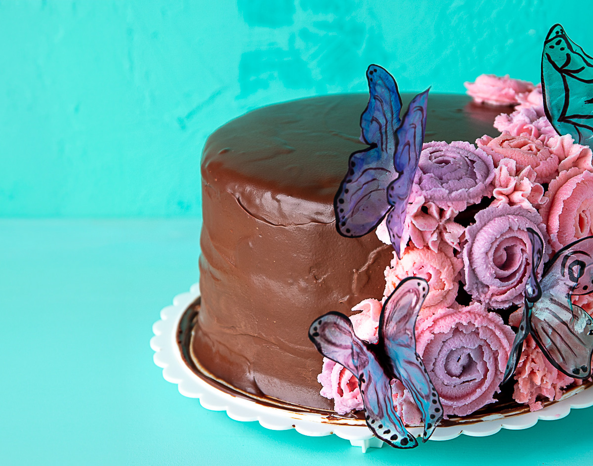 vegan birthday cake decorated with flowers and butterflies.