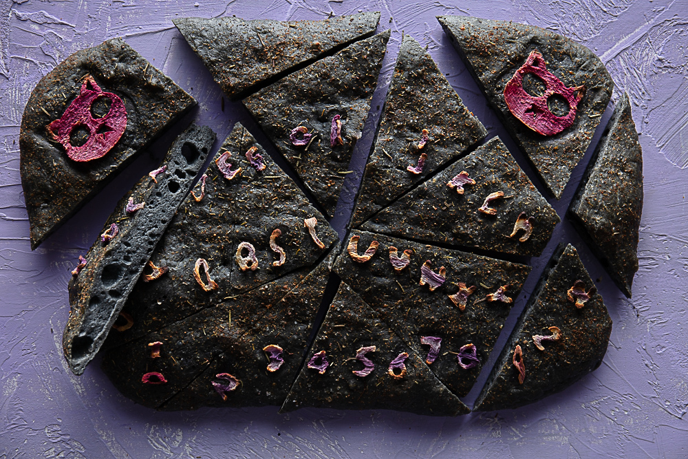 spooky vegan focaccia bread cut into pieces showing the light and fluffy inside texture