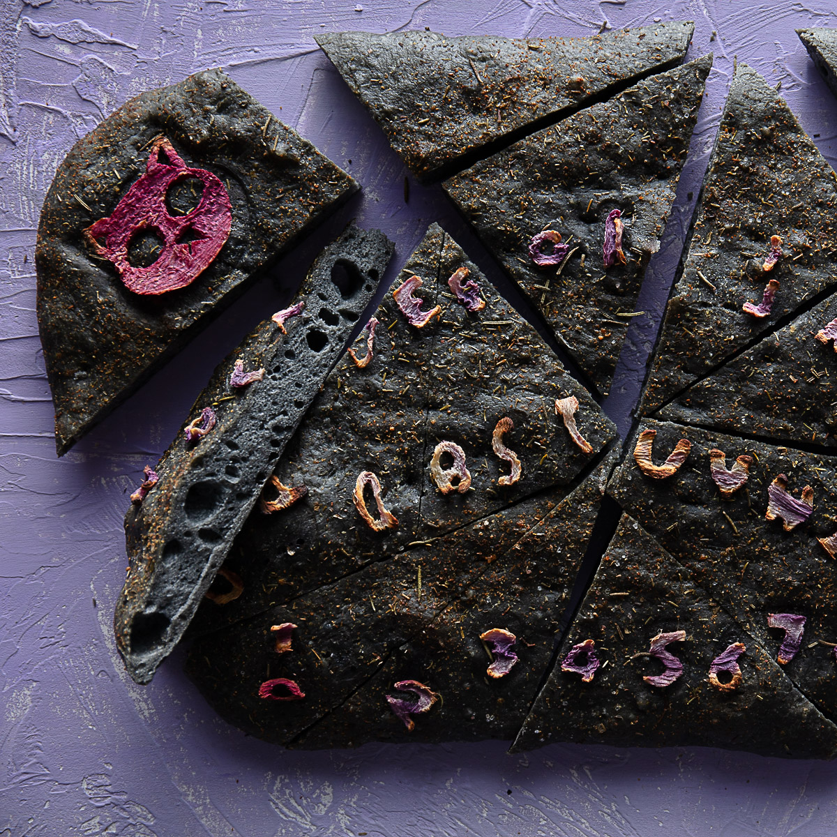 black focaccia with purple veggie focaccia art