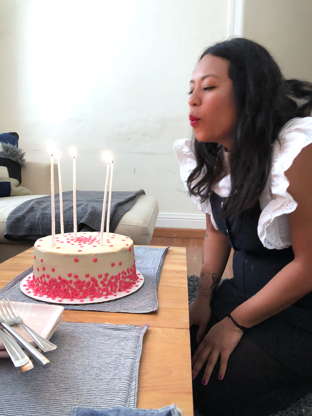 Pamela blowing out her birthday candles on her vegan pink funfetti birthday cake