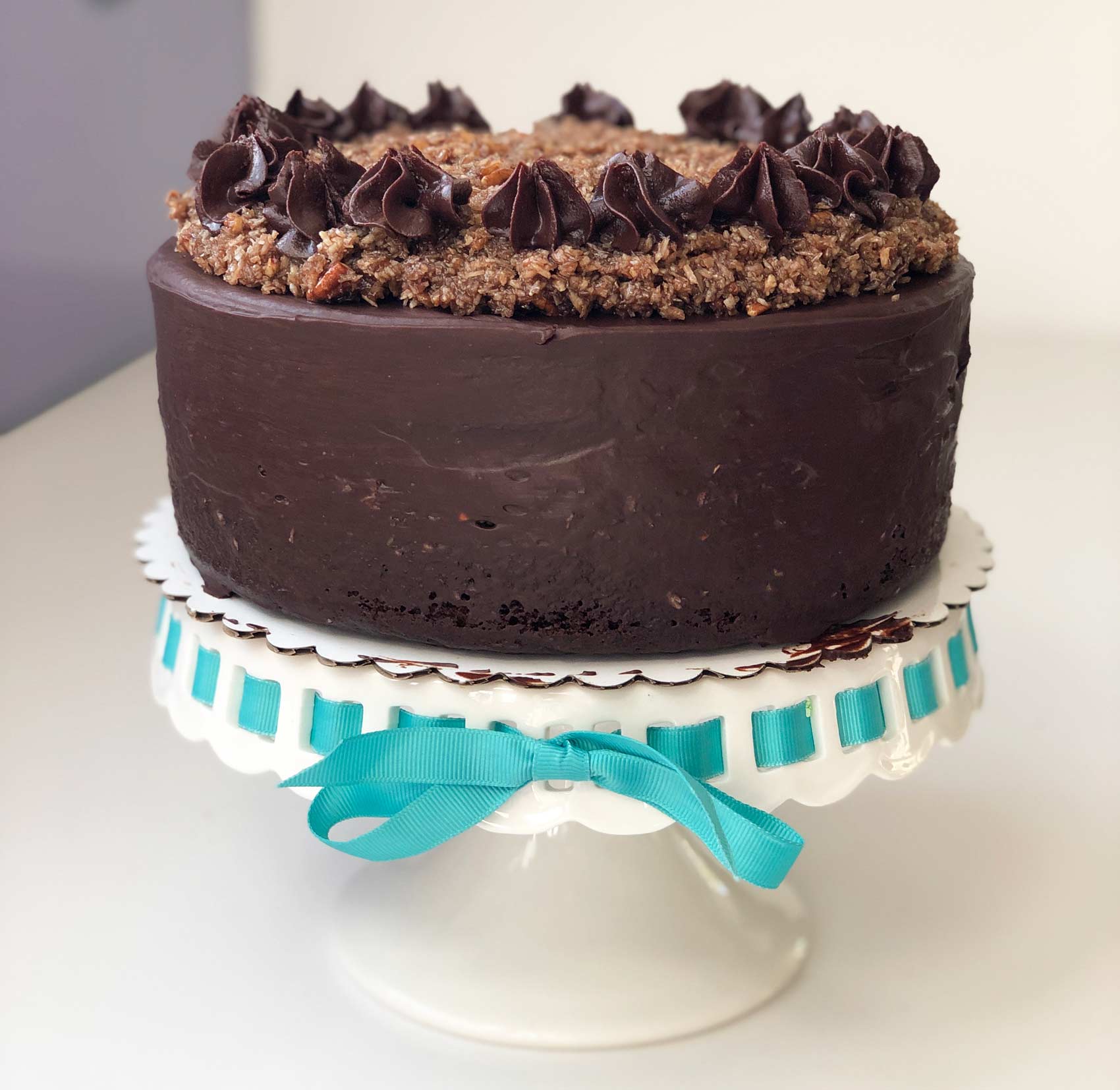 a 2-layer vegan german chocolate cake on a cake stand