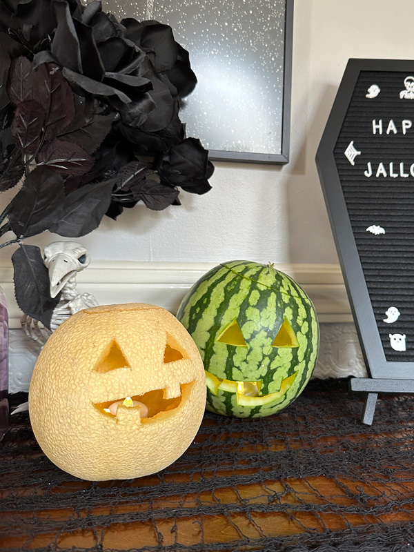 a watermelon and another melon carved into jack-o-lanterns