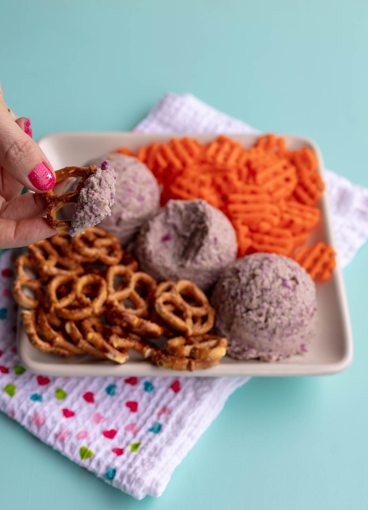 dipping a pretzel into the sauerkraut hummus