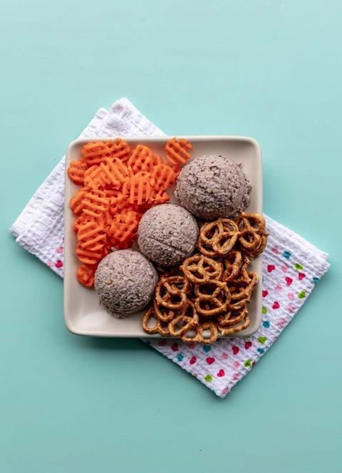 a plate of sauerkraut hummus with carrots and pretzels