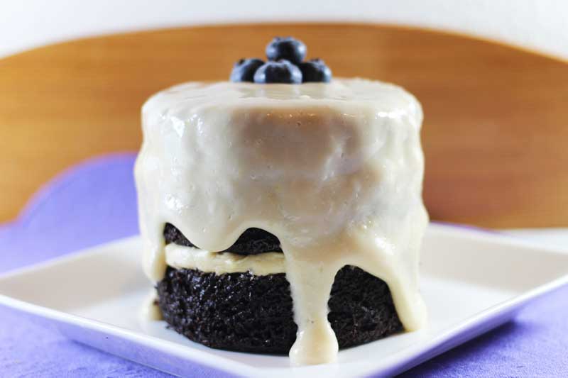 mini vegan blue velvet cake with icing and fresh blueberries on top