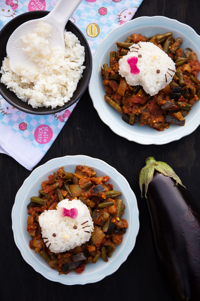 two bowls of kara kuzhambu or kara kulambu, each with a hello kitty made of white rice