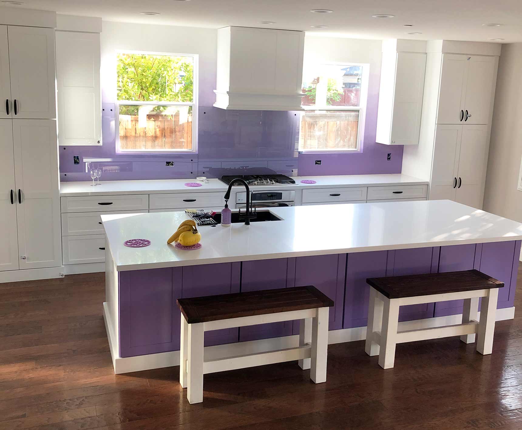 Kitchen with white stone countertops, bright purple wood cabinets