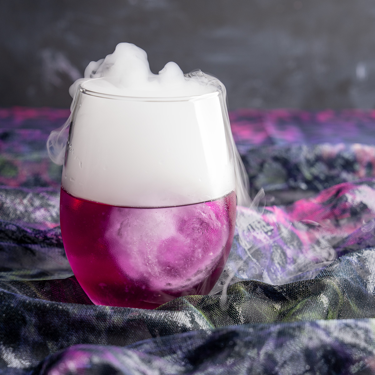 purple halloween lemonade with dry ice smoke coming out of it