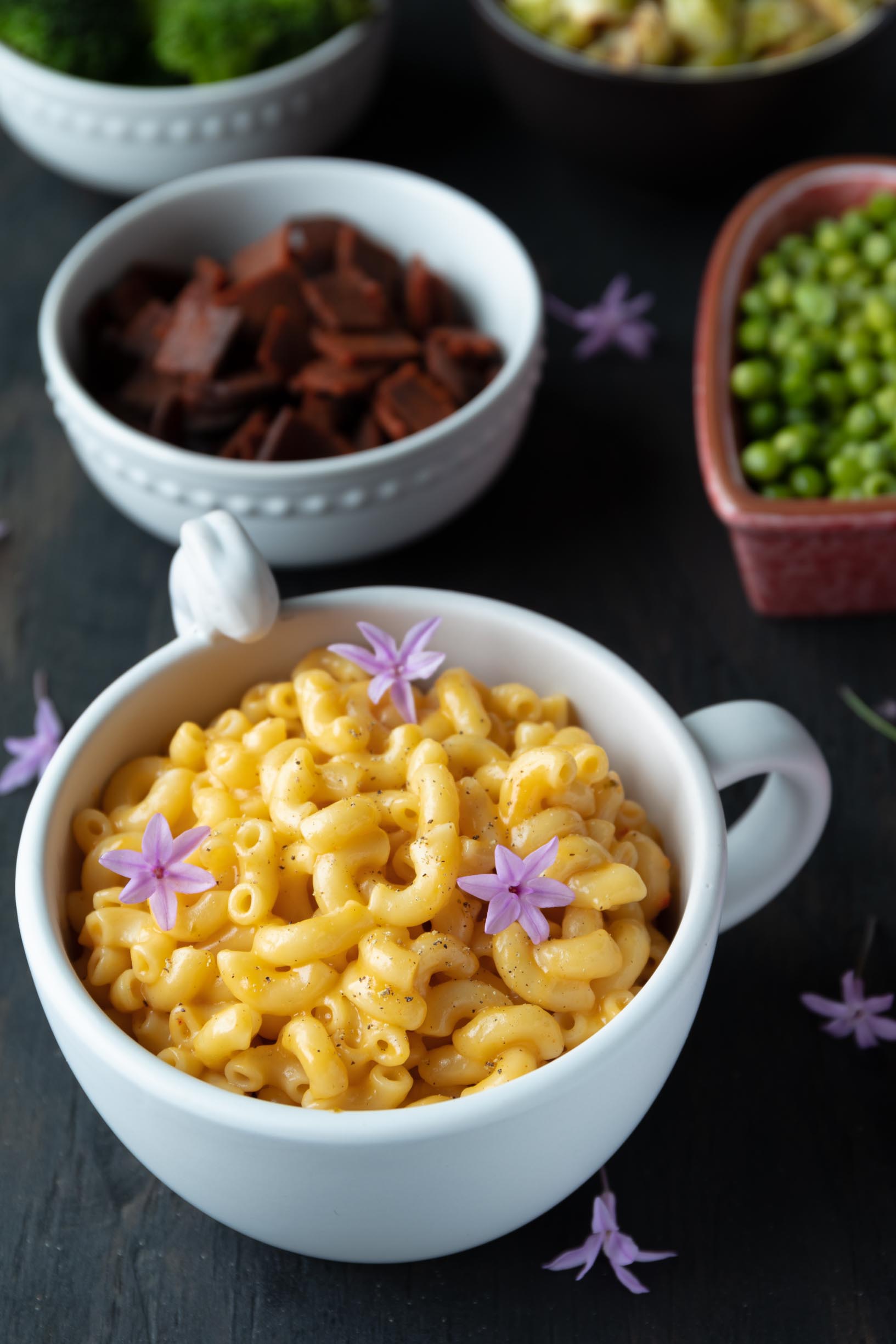 bowl of vegan mac n cheese with edible flowers on top