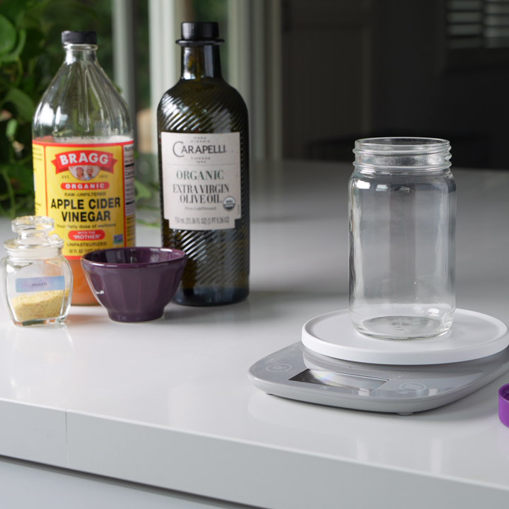 all the ingredients for the dressing next to a kitchen scale