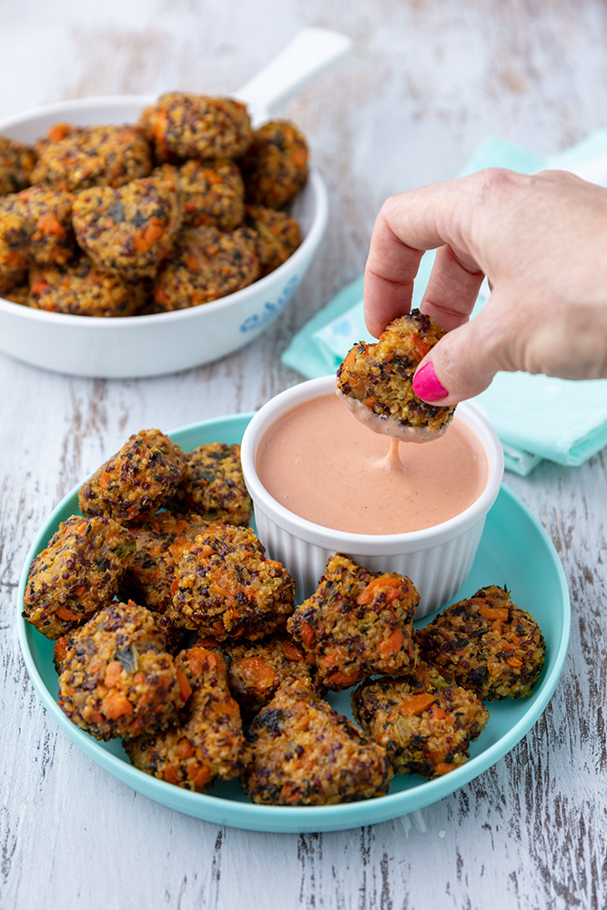 dipping a heart shaped millet tot into dip