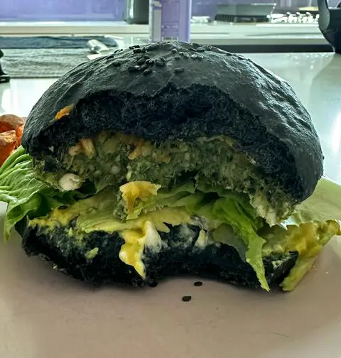 normal sized burger on a black bun.