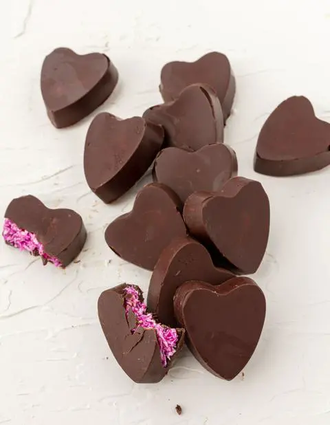 heart shaped vegan valentine chocolates with a bite missing from 2 of them.