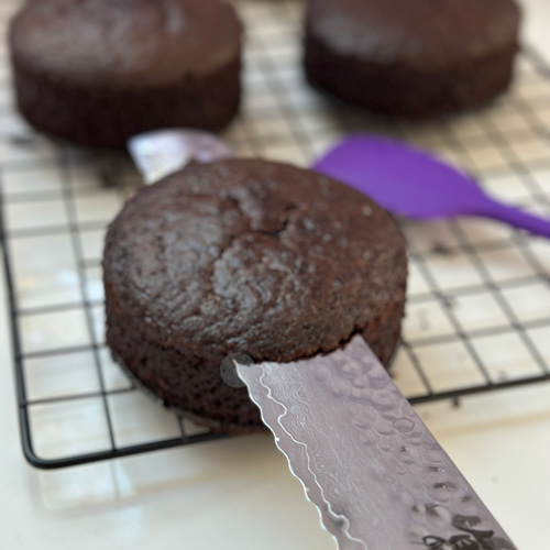 slicing the tops off the mini vegan chocolate cakes
