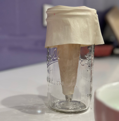 a piping bag folded over a tall jar